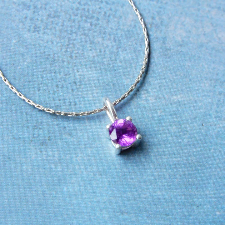 single gemstone silver necklace blue background