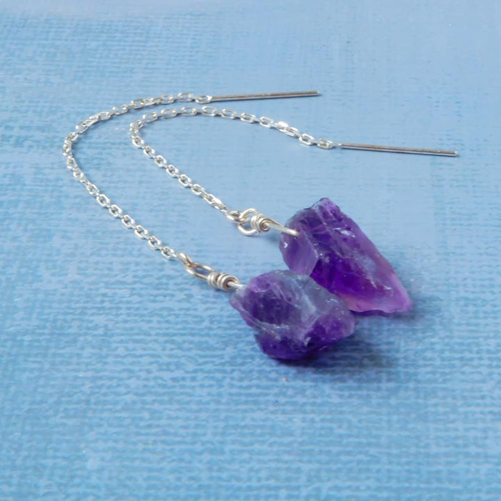 raw amethyst silver threader earrings on blue background