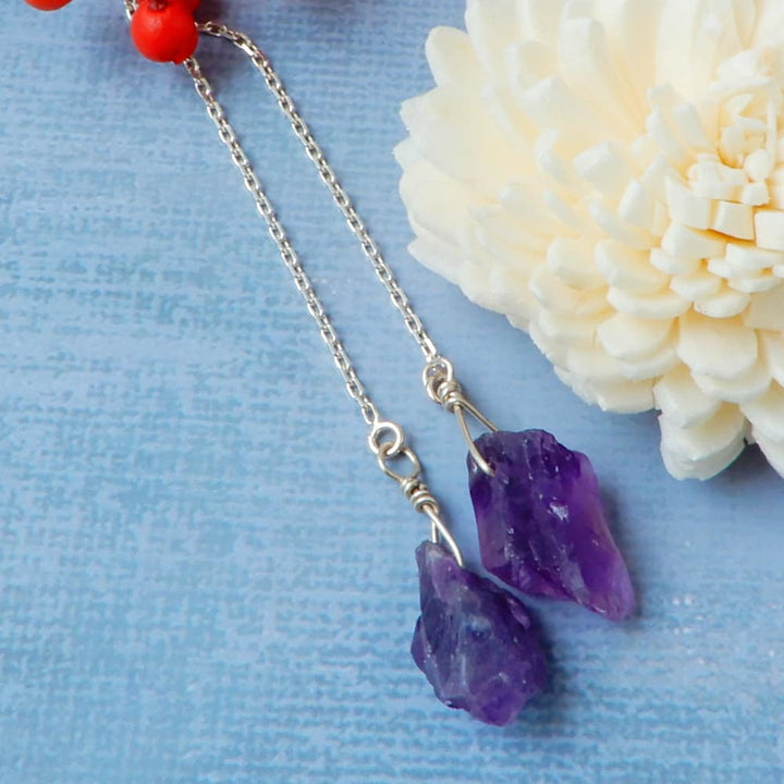 raw amethyst silver threader earrings on blue background