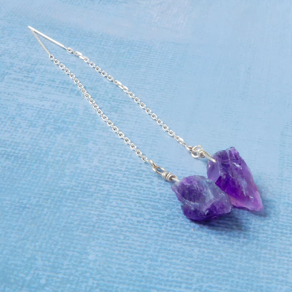 raw amethyst silver threader earrings on blue background