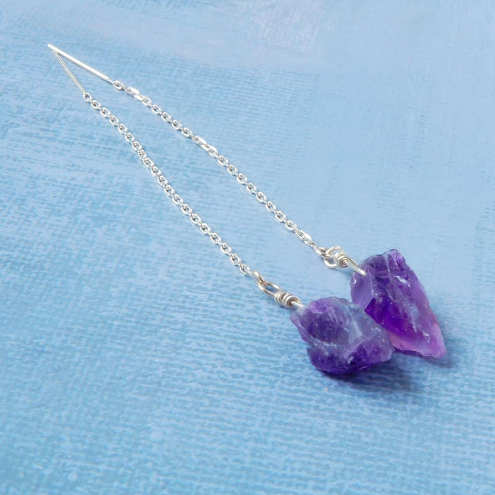 raw amethyst silver threader earrings on blue background