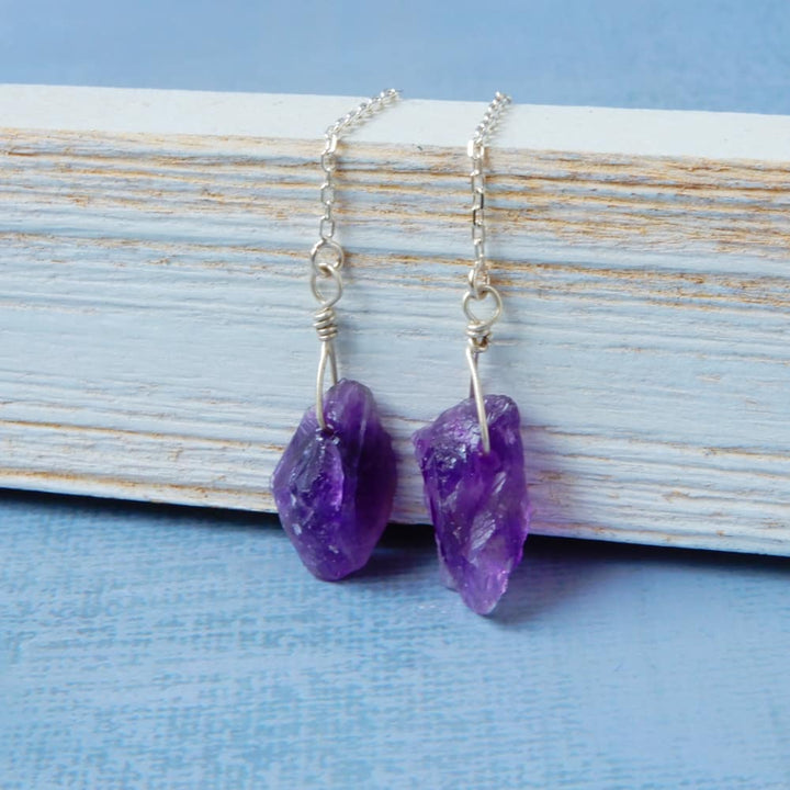 raw amethyst silver threader earrings on wood background
