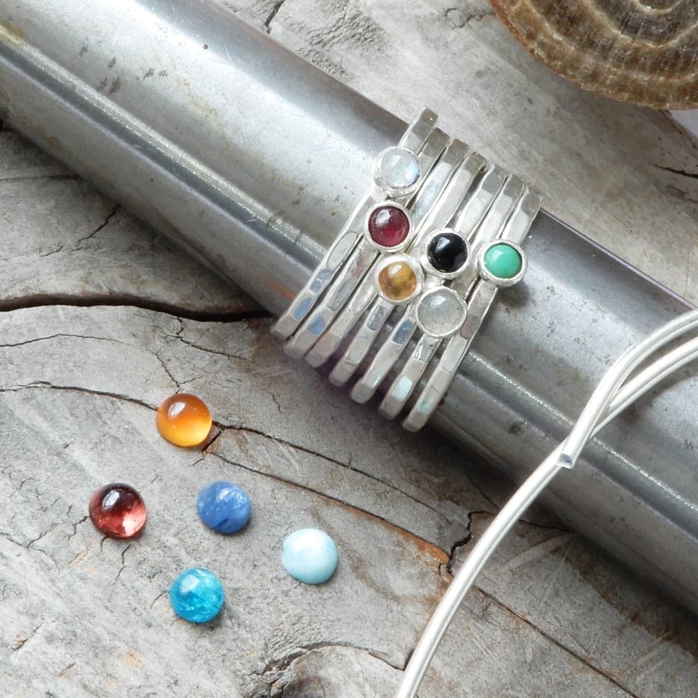 silver gemstone stacking rings on workbench