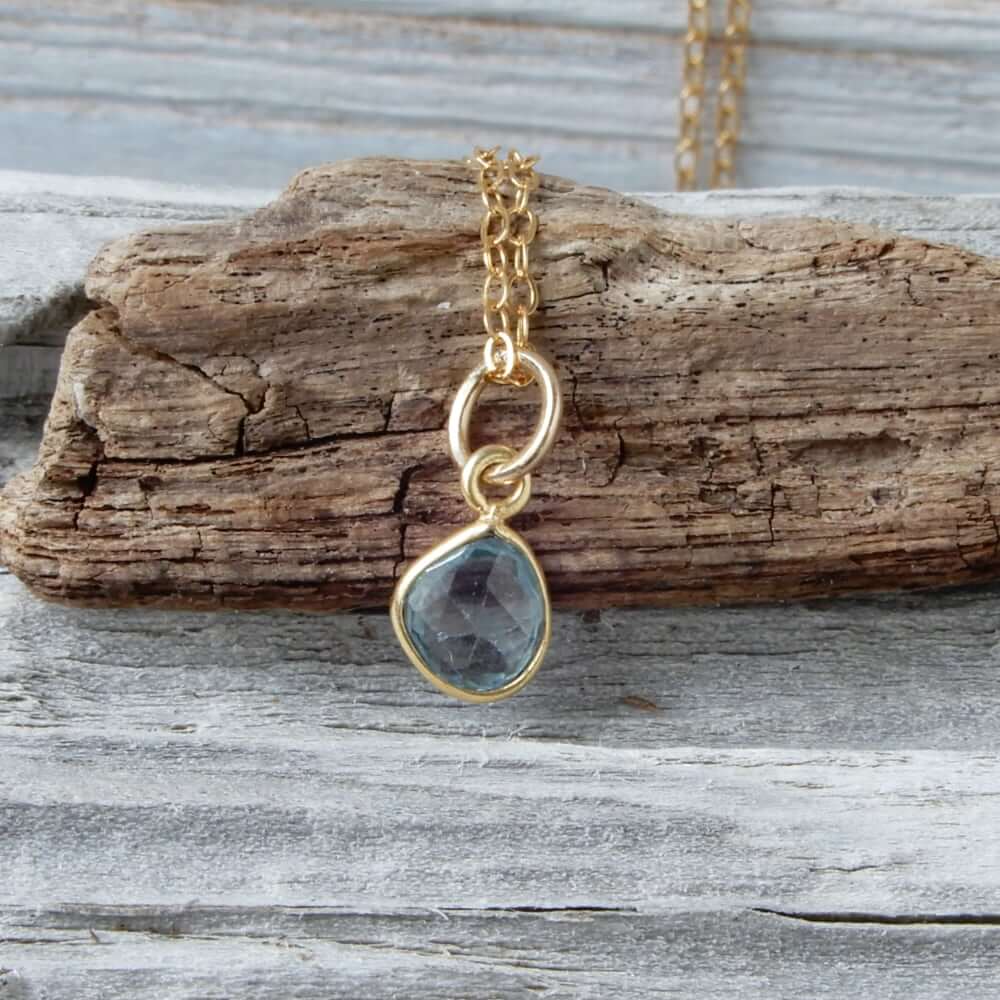 blue zircon gold jewelry necklace on wood background