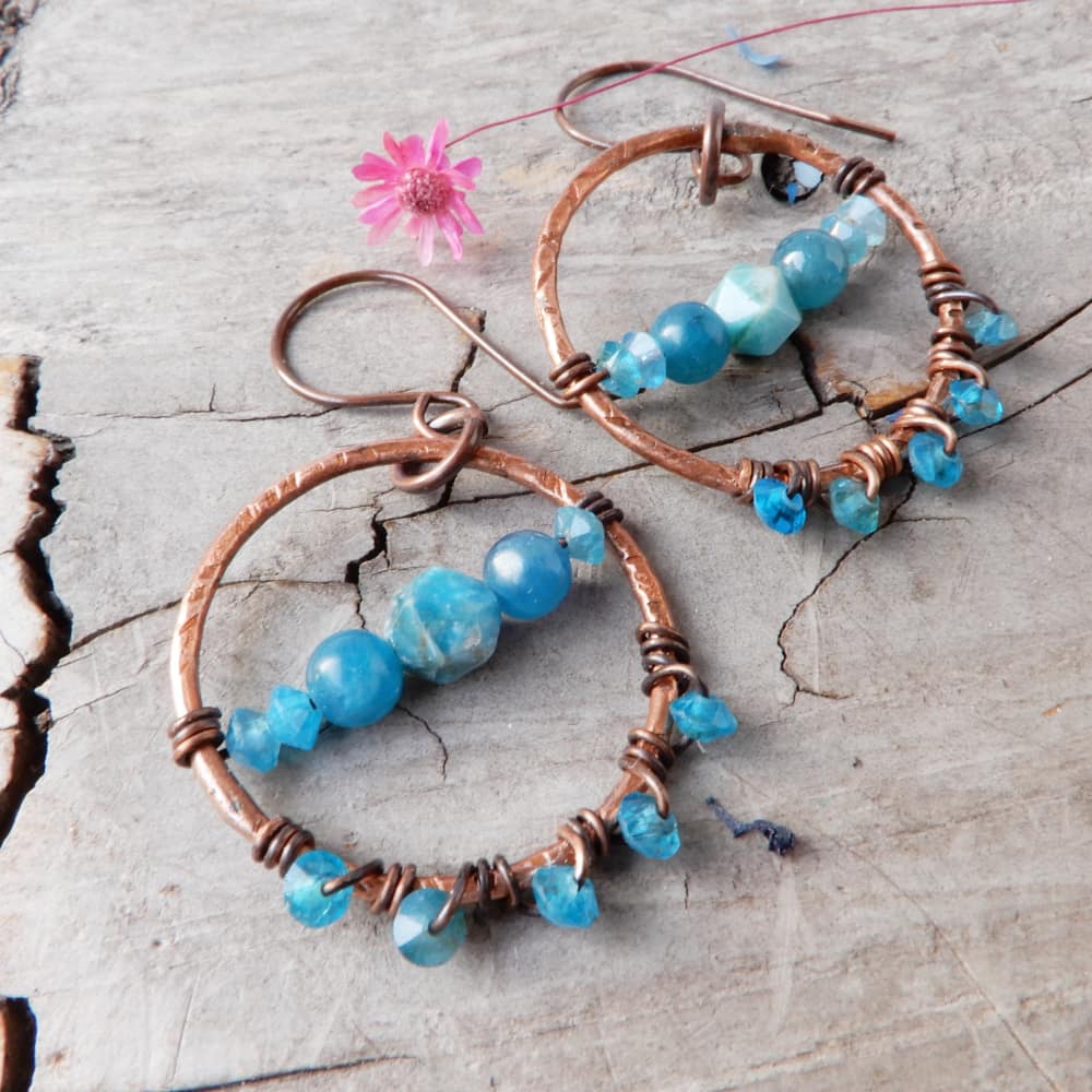 copper and apatite dangle hoop earrings on wood background