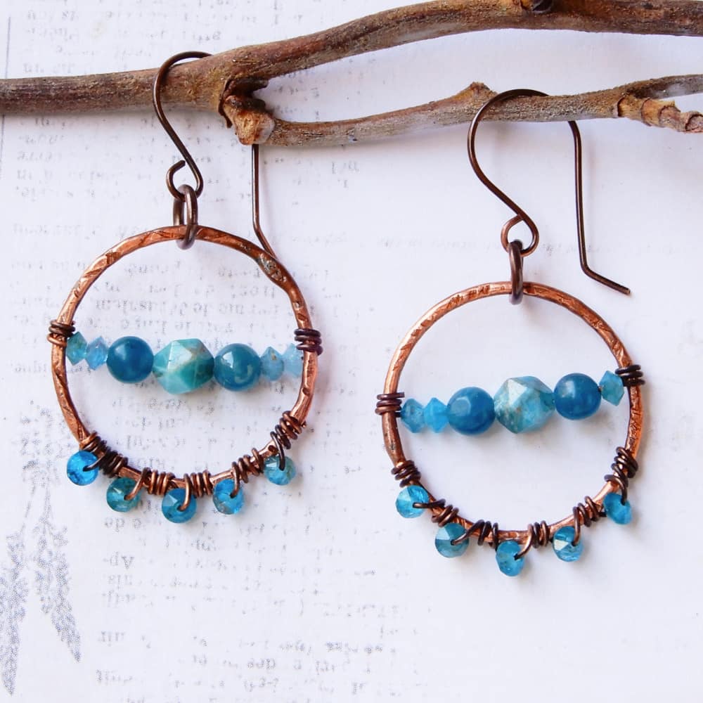 copper and apatite dangle hoop earrings on white background