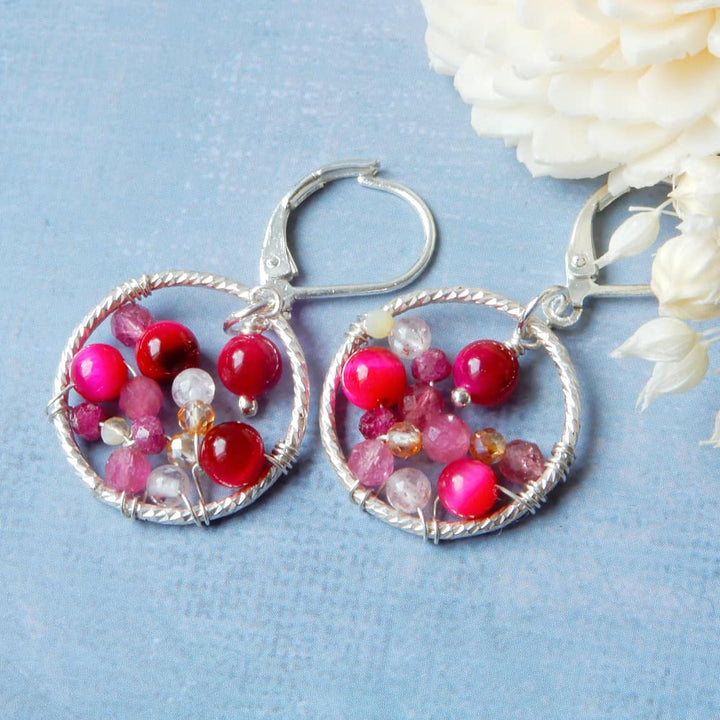 pink silver hoop earrings on blue background