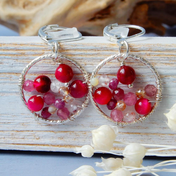 pink silver hoop earrings on white wood background
