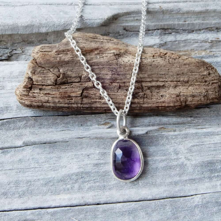 amethyst gemstone silver chain necklace on wood background