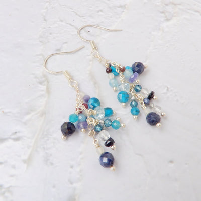 blue gemstone dangle chandelier earrings on white background