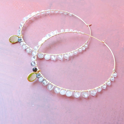 gold filled large gemstone hoops with peridot on pink background