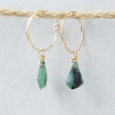 gold hoops with emerald stones